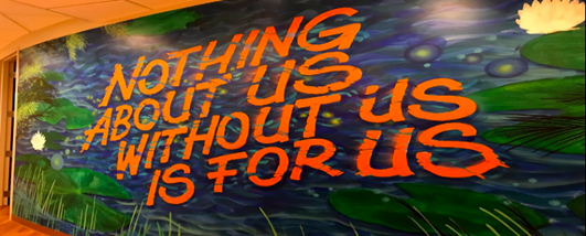 Mural that reads, nothing about us without us is for us.